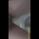 Emi hovers over a hospital toilet next to the grab bars and shits into the bowl, filmed from below. Vertical format video. Over 0.5 minutes.